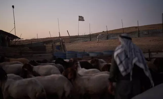 An Israeli flag, set up by settlers, waves beside a fence around a Palestinian compound's sheep pen at dusk in the northern Jordan Valley in the occupied West Bank, Tuesday, June 23, 2026.(AP Photo/Leo Correa)
