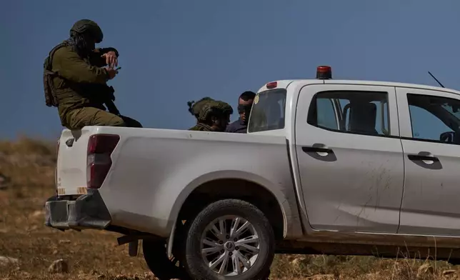 A blindfolded Palestinian is detained by Israeli soldiers after being accused by Israeli settlers of setting a field on fire near the West Bank village of Susya, in the Masafer Yatta region, Thursday, June 18, 2026.(AP Photo/Leo Correa)