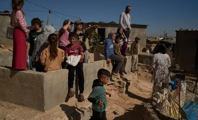 Israeli activists along with Palestinians from a local community observe the movement of settlers near the West Bank village of Susya, in the Masafer Yatta region, Thursday, June 18, 2026. (AP Photo/Leo Correa)