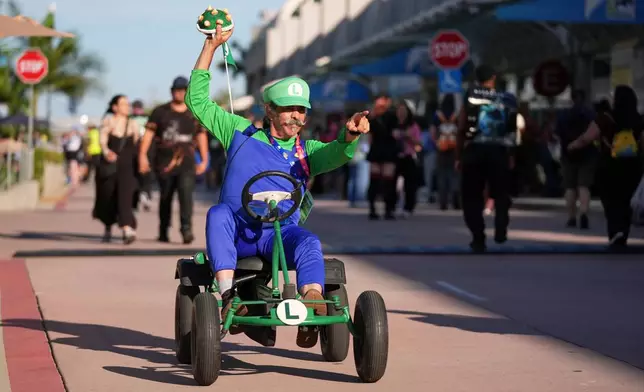 Matt Armstrong, of San Diego, dressed as the character Luigi from the Mario Kart video game series, greets attendees during preview night for Comic-Con International on Wednesday, July 22, 2026, in San Diego. (AP Photo/Chris Pizzello)