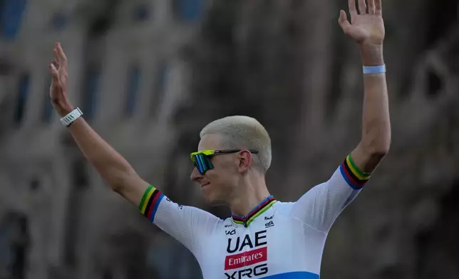 UAE Team Emirates's Tadej Pogacar waves to the crowd during a team presentation ahead of the Tour de France Cycling race, in front of the Basilica of the Sagrada Familia, in Barcelona, Spain, Thursday, July 2, 2026. (AP Photo/Mosa'ab Elshamy)