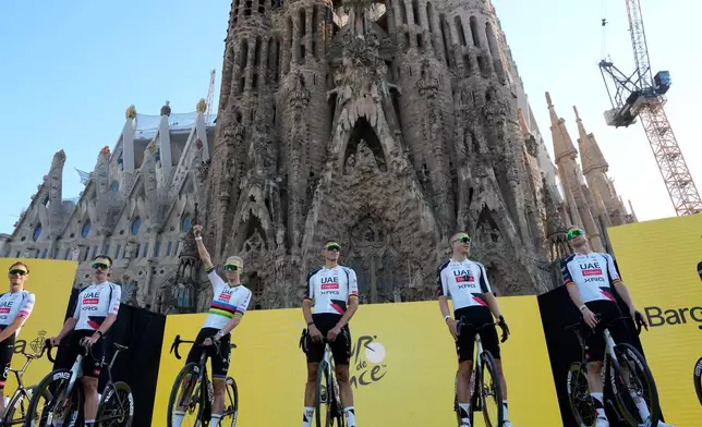 Tadej Pogacar waves to the crowds as UAE Team Emirates is presented ahead of the Tour de France Cycling race, in front of the Basilica of the Sagrada Familia in Barcelona, Spain, Thursday, July 2, 2026. (AP Photo/Mosa'ab Elshamy)