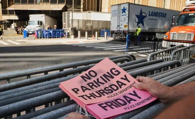 A worker holds "No Parking" signs prior to posting as trucks fill the loading dock outside New York's Madison Square Garden, Wednesday, July 1, 2026. (AP Photo/Richard Drew)