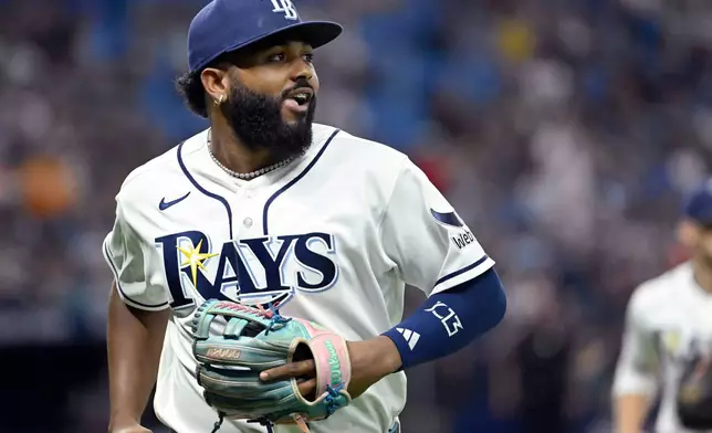 Tampa Bay Rays third baseman Junior Caminero watches a replay on his way to the dugout after the final out of the top of the seventh inning of a baseball game against the Seattle Mariners, Friday, July 10, 2026, in St. Petersburg, Fla. (AP Photo/Jason Behnken)