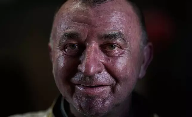 Anto Bastianovic, an employee of the 400-year-old, family-owned Grassmayr bell foundry, smiles into the camera after casting bronze bells in Innsbruck, Austria, Friday, July 17, 2026. (AP Photo/Matthias Schrader)