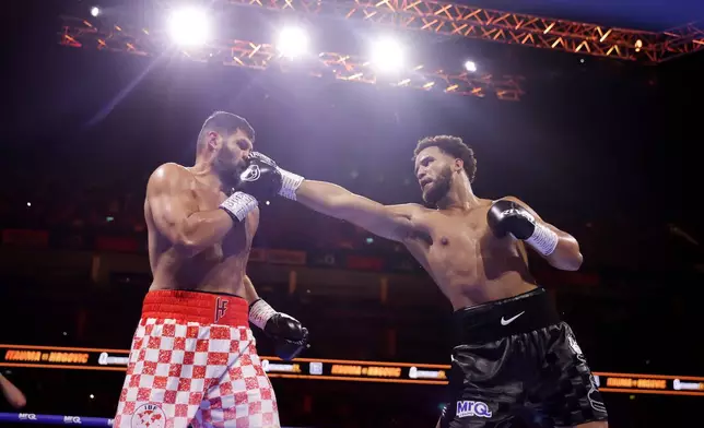 Boxer Moses Itauma, right, punches Filip Hrgovic during their vacant IBF world heavyweight title, Saturday, Aug. 29, 2026, in London. (Steven Paston/PA via AP)