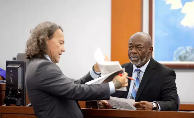 Defense attorney Michael Sanft shows exhibits to former Las Vegas Metro Police Officer Charlie Mangrum during the Duane Davis trial, related to the 1996 killing of rapper Tupac Shakur, in Clark County District Court at the Regional Justice Center in Las Vegas on Thursday, Aug. 27, 2026. (Steve Marcus/Las Vegas Sun via AP, Pool)
