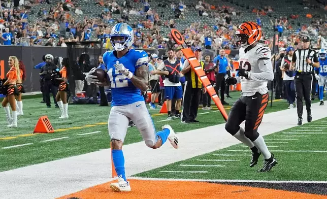 Detroit Lions wide receiver Tarik Black (12) runs for a 24-yard touchdown reception as Cincinnati Bengals linebacker Joe Giles-Harris (43) defends during the second half of a preseason NFL football game Thursday, Aug. 13, 2026, in Cincinnati. (AP Photo/Carolyn Kaster)