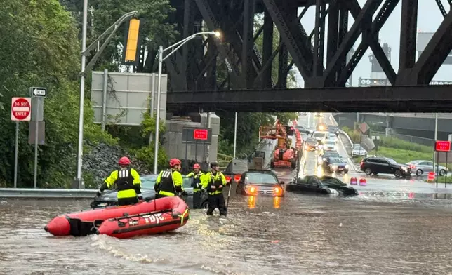 In this photo provided by the City of Jersey City, first responders try to rescue people stranded in a flooded street in Jersey City, N.J., Thursday, Aug. 20, 2026, after storms went through the area. (City of Jersey City via AP)