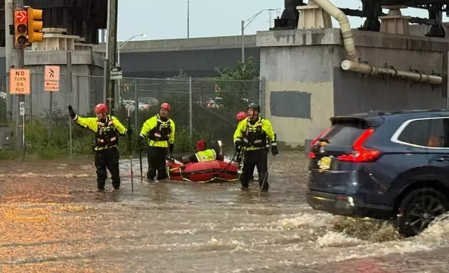 In this photo provided by the City of Jersey City, first responders try to rescue stranded people in Jersey City, N.J., Thursday, Aug. 20, 2026, after storms went through the area. (City of Jersey City via AP)