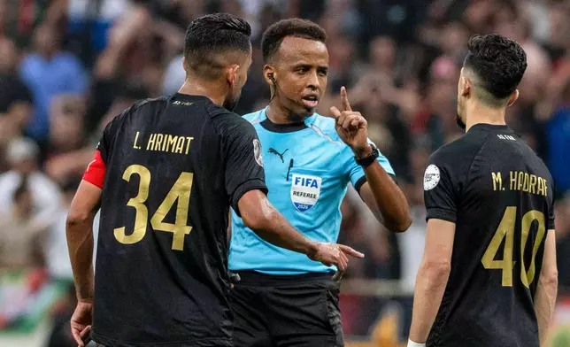 FILE - Referee Omar Artan, center, of Somalia, is confronted by players after calling a penalty kick during the CAF Champions League final soccer match between AS FAR Rabat and Mamelodi Sundowns, in Rabat, Morocco, Sunday, May 24, 2026. (AP Photo/Mosa'ab Elshamy, File)