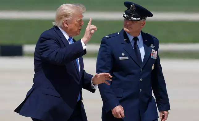 President Donald Trump, left, is escorted by Air Force Col. Christopher M. Robinson, commander of the 89th Airlift Wing, right, as he walk from Marine One to Air Force One, at Joint Base Andrews, Md., Tuesday, Aug. 4, 2026. (AP Photo/Luis M. Alvarez)