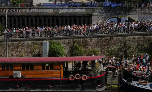 Spectators line the banks of the Seine river to watch the 20m Platform high diving at the European Aquatics Championships in Paris, Friday, Aug. 7, 2026. (AP Photo/Aurelien Morissard)