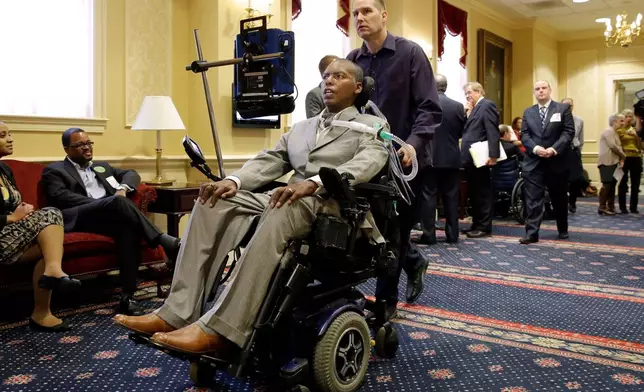 FILE - Former Baltimore Ravens NFL football player O.J. Brigance, center, current senior advisor to player development, is pushed by a nurse outside of a committee room in Annapolis, Md., March 10, 2015, after testifying to Maryland lawmakers against a right-to-die bill. (AP Photo/Patrick Semansky, File)