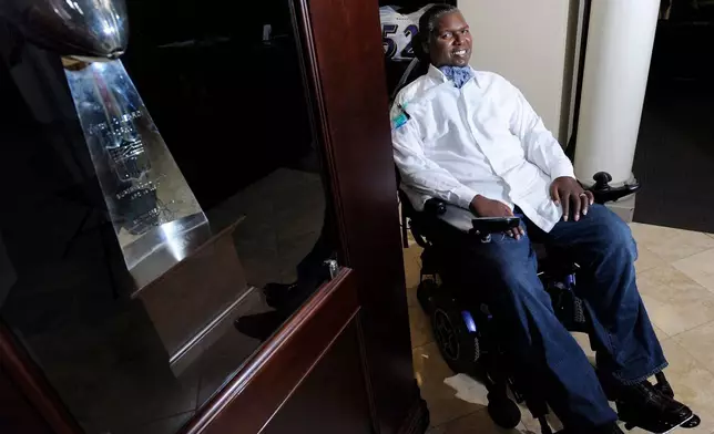 FILE - O.J. Brigance, former linebacker and current director of player development for the Baltimore Ravens, sits near the NFL football team's Vince Lombardi Trophy from the 2001 Super Bowl, in which he played, at the NFL football team's practice facility in Owings Mills, Md., Sept. 5, 2012. (AP Photo/Steve Ruark, File)