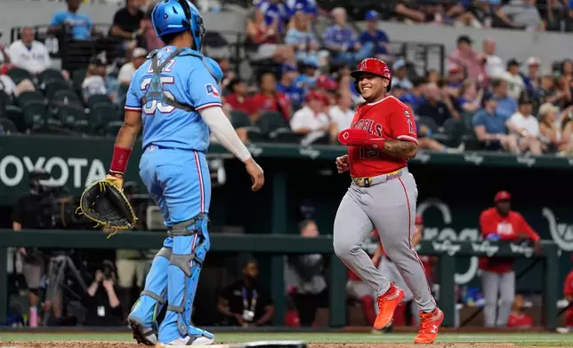Los Angeles Angels' Moisés Ballesteros, right, scores on a sacrifice fly by Josh Lowe as Texas Rangers catcher Elias Díaz (35) looks on in the eighth inning of a baseball game Sunday, Aug. 23, 2026, in Arlington, Texas. (AP Photo/Tony Gutierrez)