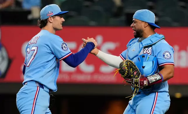Texas Rangers' Jacob Latz, left, and Elias Díaz, right, celebrate the team's win in a baseball game against the Los Angeles Angels Sunday, Aug. 23, 2026, in Arlington, Texas. (AP Photo/Tony Gutierrez)