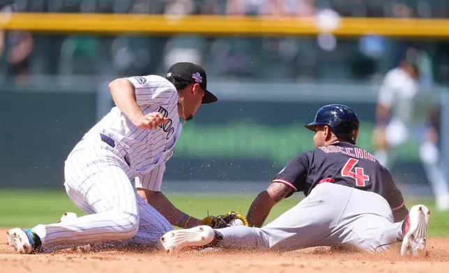 Cleveland Guardians' Brayan Rocchio, right, steals second base as Colorado Rockies shortstop Ezequiel Tovar, left, applies a late tag in the second inning of a baseball game Sunday, Aug. 23, 2026, in Denver. (AP Photo/David Zalubowski)