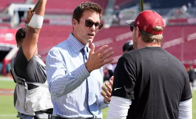 FILE - Former quarterback Tom Brady, left, talks to Tampa Bay Buccaneers offensive coordinator Liam Coen before an NFL football game between the Buccaneers and the Philadelphia Eagles, Sept. 29, 2024, in Tampa, Fla. (AP Photo/Chris O'Meara, File)