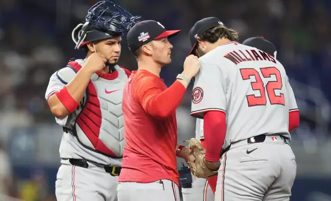 Washington Nationals manager Blake Butera, left, talks with relief pitcher Trevor Williams (32) during the fifth inning of a baseball game against the Miami Marlins, Sunday, Aug. 23, 2026, in Miami. (AP Photo/Lynne Sladky)
