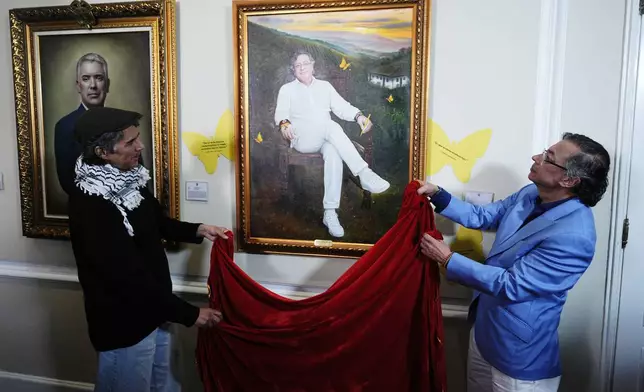 Colombia's President Gustavo Petro unveils his portrait, painted by Jaime Rojas, left, in the gallery of Colombian former presidents during his final week in office at the presidential palace in Bogota, Colombia, Monday, Aug. 3, 2026. (AP Photo/Ivan Valencia)