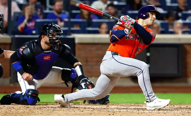 Houston Astros' Daulton Varsho, right, follows through on an RBI single against the New York Mets during the sixth inning of a baseball game, Friday, Aug. 28, 2026, in New York. (AP Photo/Noah K. Murray)
