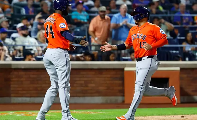 Houston Astros Yordan Alvarez (44) and Isaac Paredes shake hands after scoring against the New York Mets during the sixth inning of a baseball game, Friday, August 28, 2026, in New York. (AP Photo/Noah K. Murray)