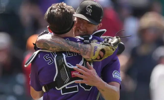 Colorado Rockies catcher Brett Sullivan, left, hugs starting pitcher Kyle Freeland, right, after Freeland got Kansas City Royals' Tyler Tolbert to fly out for the final out of a baseball game Sunday, Aug. 2, 2026, in Denver. (AP Photo/David Zalubowski)