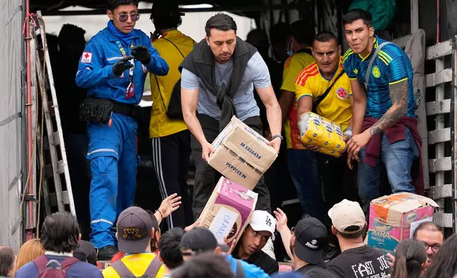 Volunteers in Bogota, Colombia, sort aid for people affected by the earthquake, Thursday, Aug. 13, 2026. (AP Photo/Fernando Vergara)