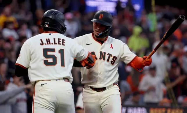 San Francisco Giants' Jung Hoo Lee (51) is congratulated by Willy Adames, right, after hitting a solo home run against the Houston Astros during the fifth inning of a baseball game in San Francisco, Monday, Aug. 10, 2026. (AP Photo/Jed Jacobsohn)