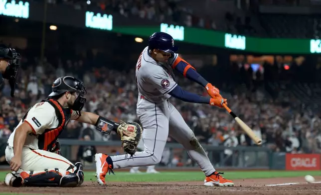 Houston Astros' Cam Smith, right, hits an RBI single in front of San Francisco Giants catcher Drew Cavanaugh, left, during the ninth inning of a baseball game in San Francisco, Monday, Aug. 10, 2026. (AP Photo/Jed Jacobsohn)