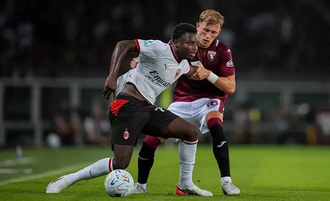 Milan's Alphadjo Cisse, left, fights for the ball with Torino FC's Marcus Pedersen during to the Serie A soccer match between Torino and Milan at the Stadio Olimpico Grande Torino in Turin, Italy, Sunday, Aug. 23, 2026 (Marco Alpozzi/LaPresse via AP)