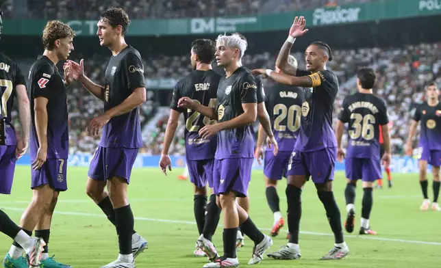 Barcelona's Fermin Lopez, left, celebrates after scoring his side's his fifth goal during a Spanish La Liga soccer match between Elche and Barcelona in Elche, Spain, Sunday, Aug. 23, 2026. (AP Photo/Alberto Saiz)