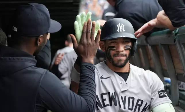 New York Yankees' José Caballero is greeted in the dugout after hitting a two-run home run against the Chicago Cubs during the third inning of a baseball game Sunday, Aug. 2, 2026, in Chicago. (AP Photo/David Banks)