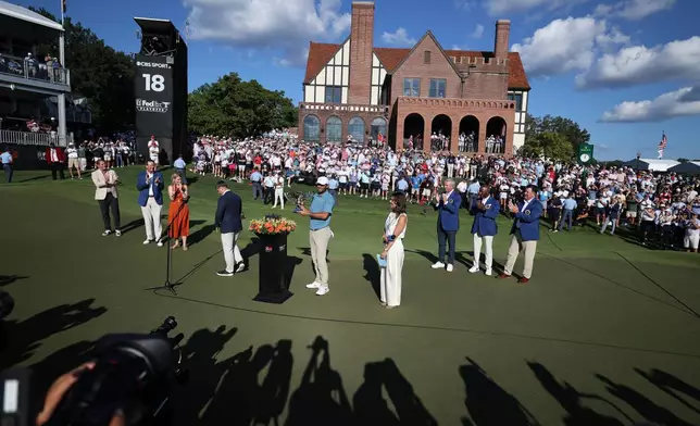 Scottie Scheffler holds the trophy after winning on the18th green during the final round of the PGA Tour Championship golf tournament Sunday, Aug. 30, 2026, in Atlanta. (AP Photo/Colin Hubbard)