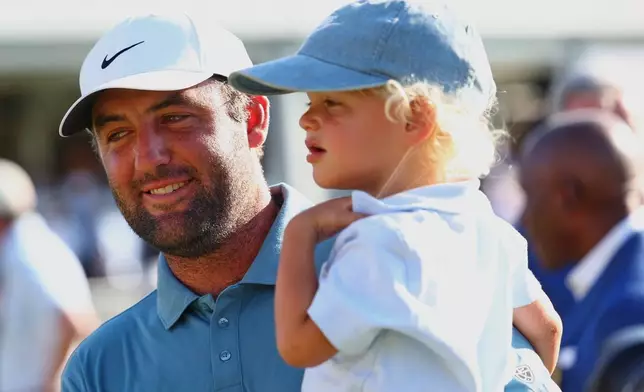 Scottie Scheffler holds his child Bennett after winning the PGA Tour Championship golf tournament Sunday, Aug. 30, 2026, in Atlanta. (AP Photo/Colin Hubbard)