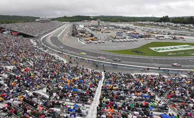 People watch as cars make their way through Turn 1 during a NASCAR Cup Series auto race, Sunday, Aug. 23, 2026, at New Hampshire Motor Speedway, in Loudon, N.H. (AP Photo/Steven Senne)