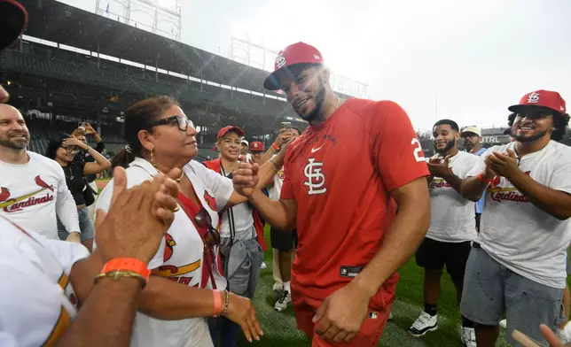 St. Louis Cardinals' Joshua Baez, right, celebrates with his mother Yris Carmen Baez, left, after defeating the Chicago Cubs in a baseball game in Chicago, Saturday, Aug. 15, 2026. (AP Photo/Paul Beaty)