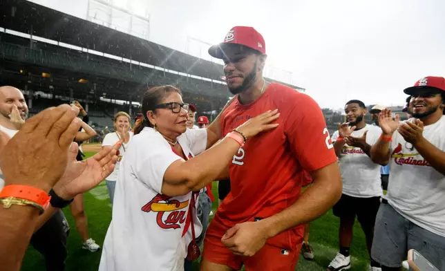 St. Louis Cardinals' Joshua Baez, right, gets a hug from his mother Yris Carmen Baez after defeating the Chicago Cubs in a baseball game in Chicago, Saturday, Aug. 15, 2026. (AP Photo/Paul Beaty)
