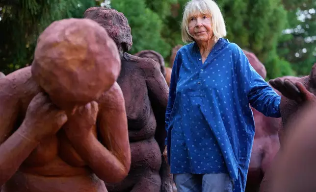 Artist Suse Lowenstein, whose son, Alex, was killed in the bombing of Pan Am Flight 103 over Lockerbie, Scotland, poses for a photograph amongst the figures thats make up her sculpture titled "Dark Elegy" in her backyard in Montauk, N.Y., Wednesday, Aug. 19, 2026. (AP Photo/Seth Wenig)