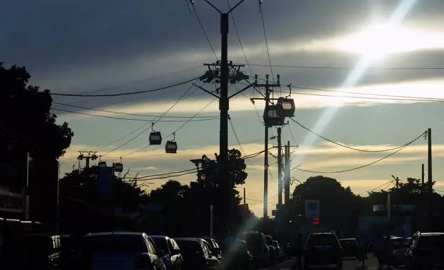 Cable cars cut across the skyline during testing in Antananarivo, Madagascar, Sunday, April 6, 2025. (AP Photo/Alexander Joe)