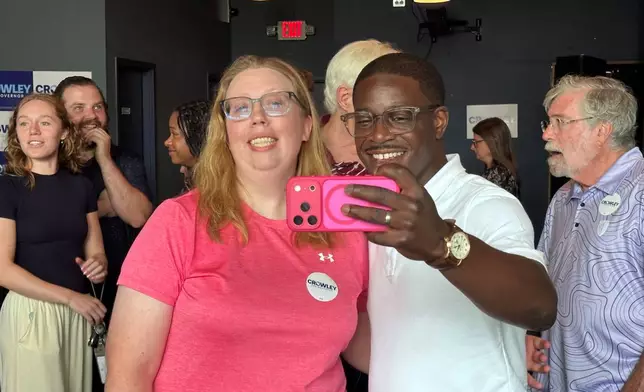 David Crowley, Democratic candidate for Wisconsin governor, takes a selfie photo with supporter Abigail Tessmann during a campaign stop Wednesday, Aug. 5, 2026, in Madison, Wis. (AP Photo/Scott Bauer)