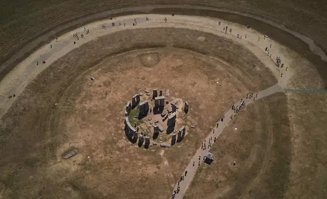 A general view of the ancient stone circle Stonehenge amid dried grass in Wiltshire, England, Thursday, Aug. 13, 2026. (AP Photo/Kin Cheung)