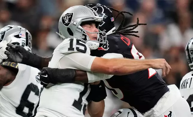 Las Vegas Raiders quarterback Fernando Mendoza (15) is hit by Houston Texans defensive end Jadeveon Clowney (90) during the first half of an NFL preseason football game Thursday, Aug. 20, 2026, in Houston. (AP Photo/Ashley Landis)