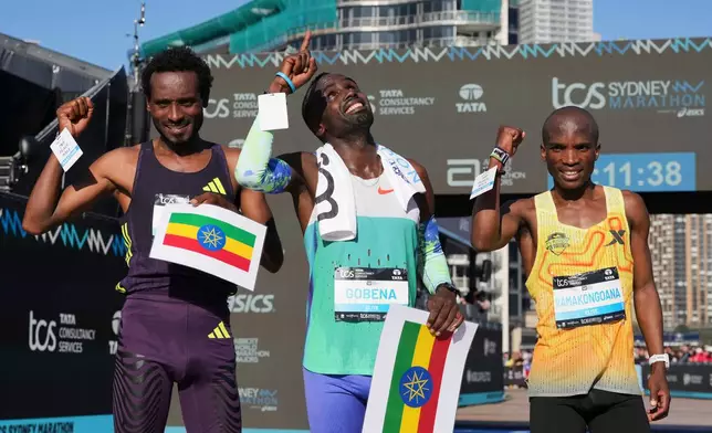 Race winner Addisu Gobena, centre, of Ethiopia stands with compatriot and second placed Chimdessa Debele, left, and third placed Tebello Ramakongoana of Lesotho following the Sydney Marathon, in Sydney, Sunday, Aug. 30, 2026. (AP Photo/Mark Baker)