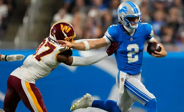 Detroit Lions quarterback Luke Altmyer (2) runs the ball against Washington Commanders Car'lin Vigers (37) during a preseason NFL football game, Saturday, Aug. 22, 2026, in Detroit. (AP Photo/Paul Sancya)