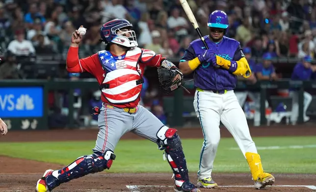 Cincinnati Reds catcher Jose Trevino, left, throws to second base as Arizona Diamondbacks' Gabriel Moreno looks on during the first inning of a baseball game, Friday, Aug. 21, 2026, in Phoenix. (AP Photo/Ross D. Franklin)