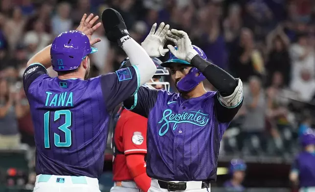 Arizona Diamondbacks' Jordan Lawlar, right, celebrates his two-run home run against the Cincinnati Reds with Diamondbacks' Tim Tawa (13) during the second inning of a baseball game, Friday, Aug. 21, 2026, in Phoenix. (AP Photo/Ross D. Franklin)