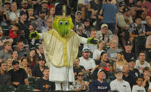 Chicago White Sox mascot Southpaw stands on the dugout wearing a pope outfit during the seventh inning of a baseball game against the Cincinnati Reds, Tuesday, Aug. 11, 2026, in Chicago. (AP Photo/Melissa Tamez)