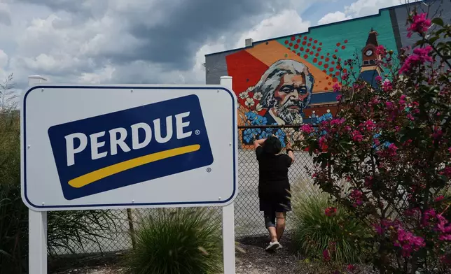 A Honduran woman poses for a portrait outside the Perdue Farms poultry plant, where she worked for more than two decades before losing her job the previous year after her TPS expired in Salisbury, Md., Saturday, Aug. 1, 2026. (AP Photo/Luis Andres Henao)